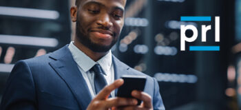 Black business man holding cell phone.PRL logo in upper right corner